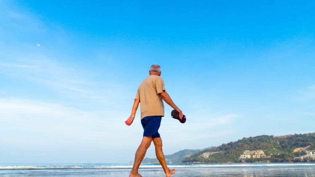 Older man walking on the beach
