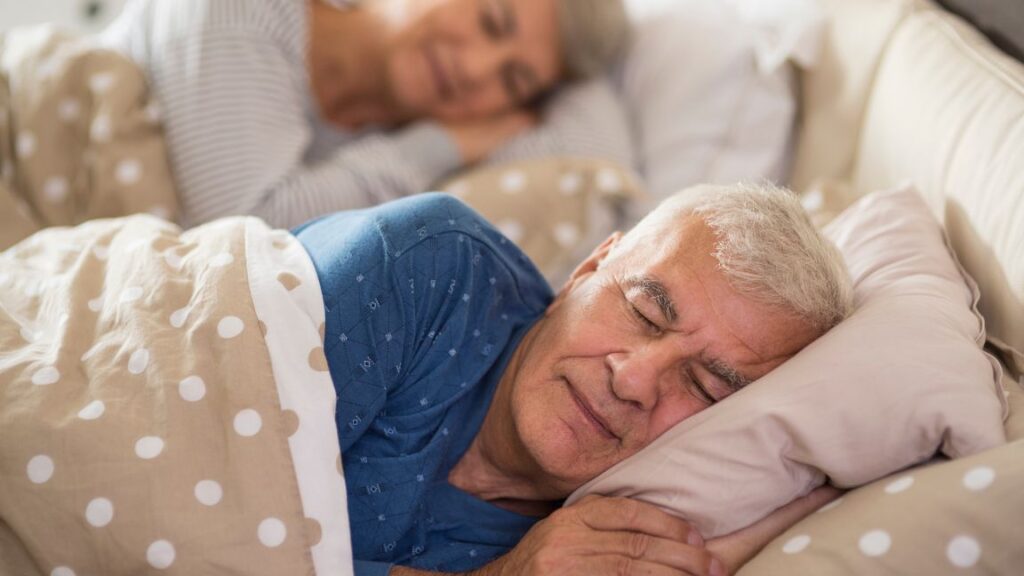 Elderly couple sleeping on the bed